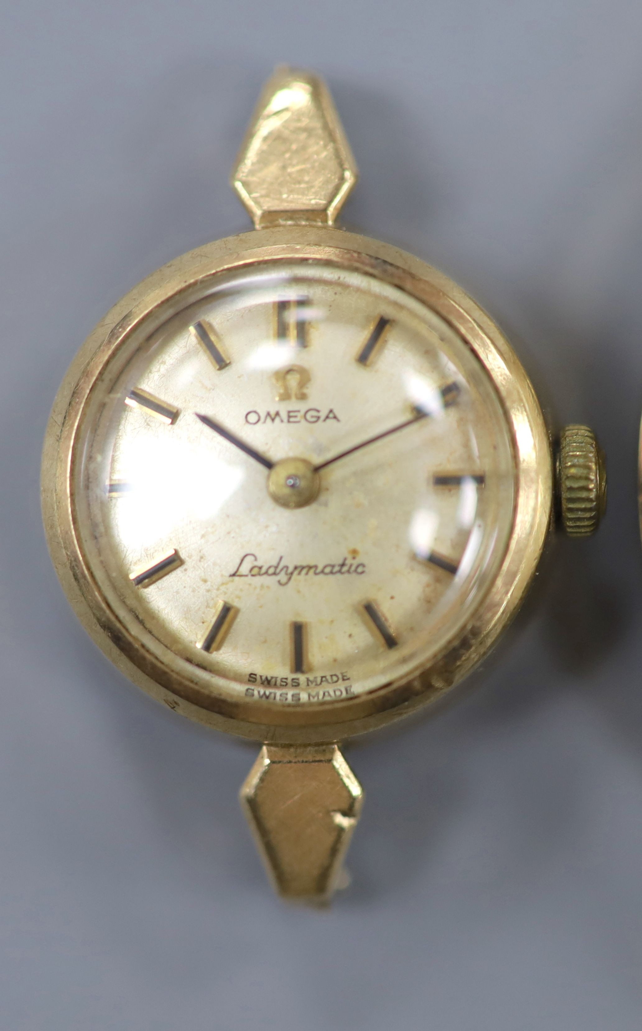 A gentleman's 9ct gold watch Longines manual wind wrist watch (no strap) and a lady's yellow metal Omega Ladymatic wrist watch (no strap), gross weight 39.5 grams.